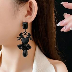 Detail of gothic angel heart earrings featuring black beads and drop pendant on model