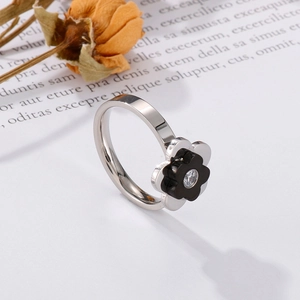 Detail showing a silver flower ring with black petals and a central zircon stone