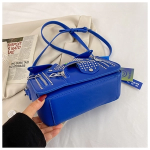 Detailed close-up of Klein blue motorcycle jacket crossbody bag with metallic studs