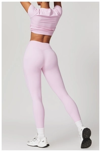 Detailansicht der Rückseite eines hellrosa Yoga-Sets mit Leggings und bauchfreiem Oberteil