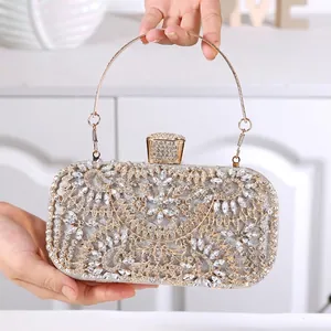 Detail of evening clutch bag featuring radiant floral rhinestone patterns and golden handle