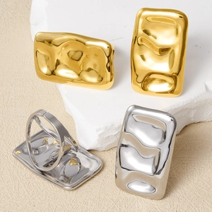Adjustable wavy rings in gold and silver finish displayed on minimalist stone props