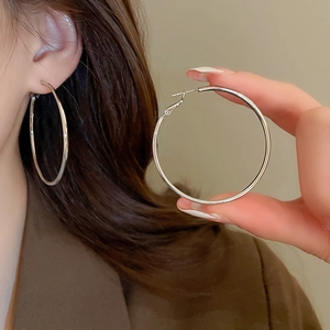 Close-up of large silver hoop earrings showcasing sleek metallic finish and minimalist style