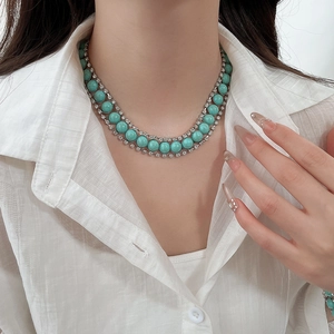Détail d'un collier multicouche en résine turquoise avec accents de diamants argentés