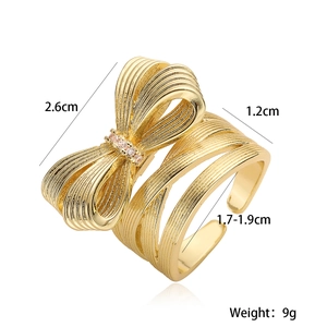 18K gold plated bow ring with brushed texture and small zircon accents on white background