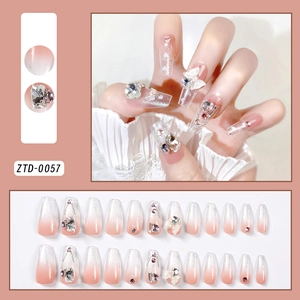 Detail view of pink gradient press-on nails with sparkling rhinestones and pearls