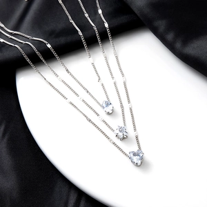 Minimalist layered silver necklaces with star, heart, and teardrop crystal pendants