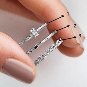 Detailed close-up of three sparkling zircon stackable rings in polished silver finish