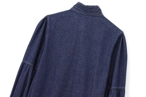Detailed view of deep blue denim top featuring a stand-up collar and ruffled sleeve texture