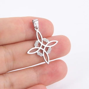 Polished stainless steel Celtic knot pendant held by hand to show actual size