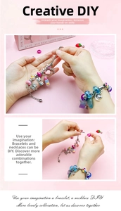 Close-up of pink DIY jewelry set with unicorn charms, rainbow beads and silver chains
