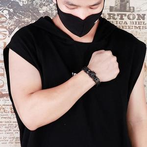 Detail of men's black punk wolf head bracelet featuring steel chain and leather cord