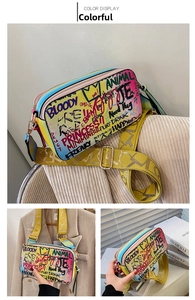 Detail of colorful graffiti crossbody bag with yellow wide strap and crown pattern