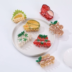 Minimalist summer fruit hair claws featuring strawberry and grape shapes on white plate