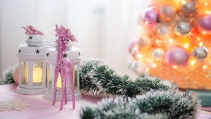 Close-up of dark green tinsel with white tips, pink reindeer decor, and star lantern set