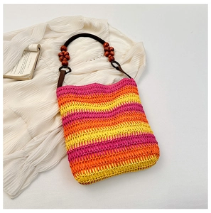 Detail of colorful rainbow hand-woven straw shoulder bag with wooden beaded handles