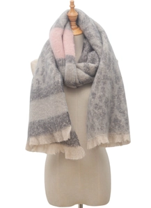 Detail showing soft texture and tassels of a grey leopard print scarf on a wooden mannequin