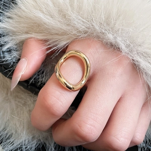 Detail of a minimalist gold wavy open ring with a polished finish on a luxury background