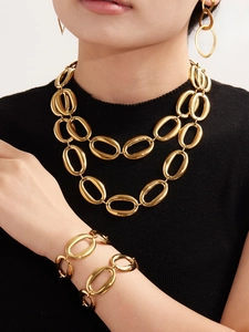 Polished gold stainless steel oval link necklace and bracelet set on a female model