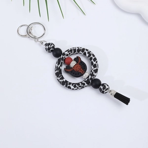Close-up of silicone keychain with black and white leopard pattern and a bull head charm