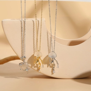 Close-up of jellyfish and heart-shaped pendants with matte finish on 14K gold-plated chains