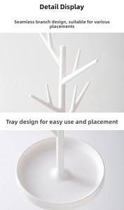 Detail of white tree jewelry rack showing seamless branches and a round base tray