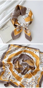 Detail of printed silk square scarf featuring deer and leaf motifs in warm brown and yellow