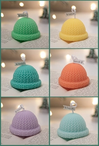 Macro detail of six colorful knit hat shaped scented candles with festive decoration