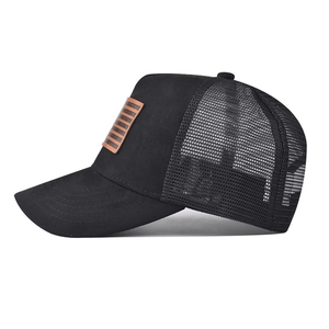 Dettaglio del cappello trucker in pelle scamosciata nera con rete e patch in cuoio
