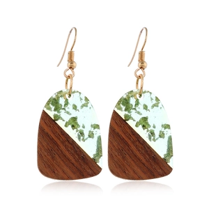 Detail of vintage geometric earrings with dark wood and green glitter resin pendants