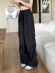 Detail view of black cargo pants showing drawstring elastic waist and side pockets