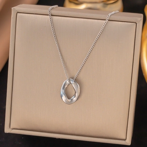 Silver titanium steel necklace with irregular organic round pendant on jewelry box