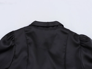 Detail shot of the back collar and puff sleeves on this black satin mini dress