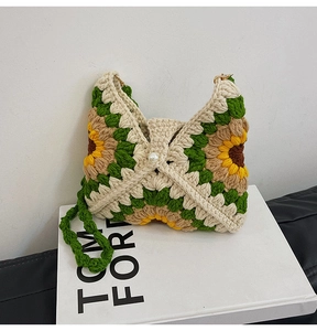 Close-up of handmade sunflower crochet bag featuring white pearl buckle and green strap