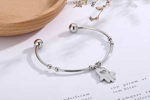 Detail of silver Hamsa Hand bangle with hollow heart design and adjustable bead details
