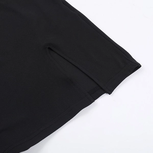 Detailed close-up of the split hem and fine stitching on a black bodycon dress