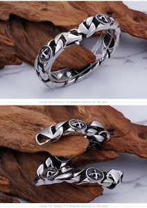 Close-up of vintage silver cross anchor bracelet on wood stand with marble background