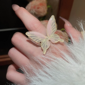Close-up of pink butterfly ring with faux pearls and sparkling glitter on hand