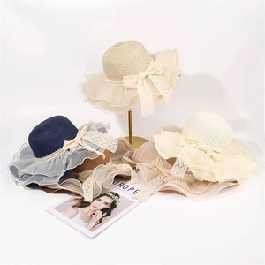 Straw sun hats with large organza bows in navy, beige, and cream for beach fashion