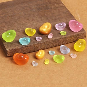 Close-up of colorful luminous resin gold ingots scattered on a textured wooden background