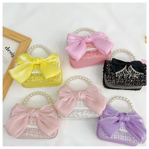 Flat lay of colorful mini tweed handbags with pearl handles and large satin bows