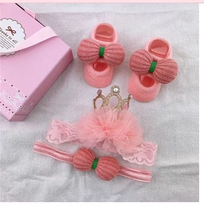 Detailed gift set featuring pink baby socks and headbands with lace and bow details