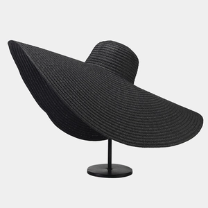 Close-up of the wide-brimmed black straw hat showing fine woven texture and elegant waves