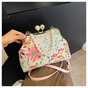 Detaillierte Stickerei von rosa Blumen auf einer Vintage-Tasche mit Perlenverschluss