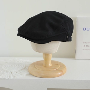 Détail de béret noir pour enfant avec boucle réglable et texture de tissu en sergé durable
