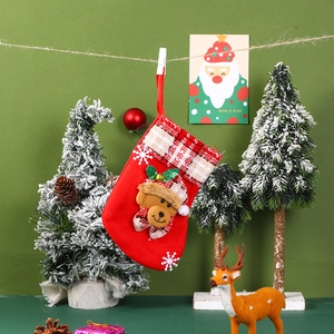 Detail of red Christmas stocking with plaid trim and 3D plush bear hanging decoration
