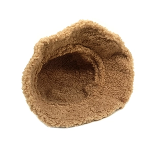 Detail of a brown fuzzy teddy fleece bucket hat featuring a round decorative side patch