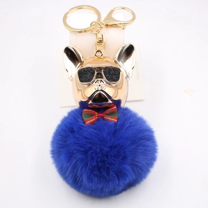Dettaglio portachiavi bulldog francese creativo con pompon blu reale e finitura dorata