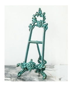 Detalle de soporte retro de hierro fundido con tallas barrocas y acabado en bronce dorado