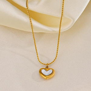 Elegant gold heart pendant necklace with white shell inlay on a silk fabric background